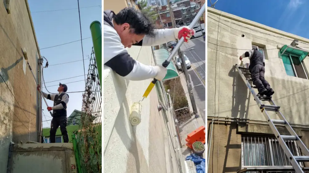 옥상 난간에서 롤러로 드라이비트 외벽을 도장하는 작업 과정